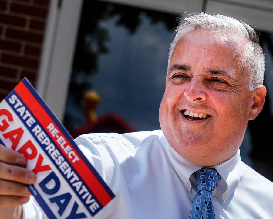 Gary Day holding a Re-Elect State Representative Gary Day sign